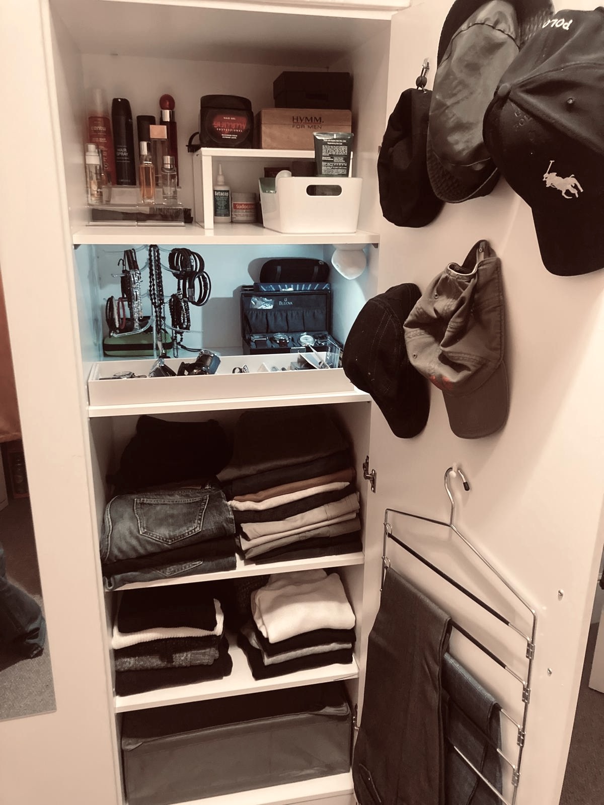Organised wardrobe with folded clothes, zoned shelves and tidy accessories